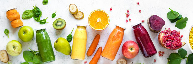 Fruit coupés et bouteilles de jus verts, jaunes, rouges, orange sur fond blanc